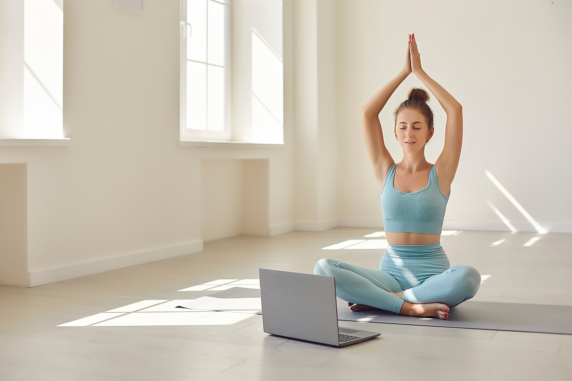 Female Yoga Coach Showing Asana in Front of Laptop during Online Video Lesson with Client